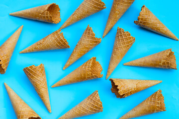 Empty ice cream cone on blue background.