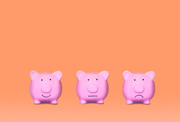Three little ceramic pigs in different moods with orange background. Mood swing bipolar disorder, depression. Concept of mood change and mental well being