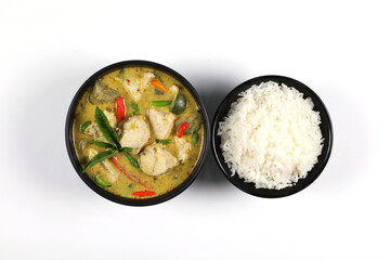 Thai food. Chicken green curry with rice in black bowl isolated on white background. Green curry chicken in top view.