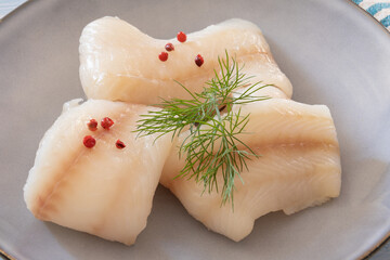 close up of raw halibut fillet on a plate