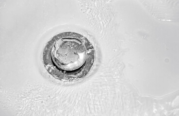 Water drain down in white washbasin