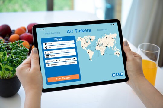 female hands holding computer tablet with application searching air tickets