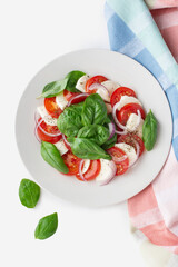 Caprese salad with tomatoes and mozzarella on a white table