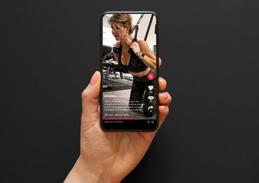 Video with a woman working out in a gym shared on social media app viewed on a mobile phone