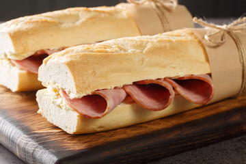  French Sandwich Jambon-Beurre made from a baguette with butter and ham closeup on the wooden...
