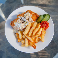 Appetizing dish with French fries and kebab. Potatoes and meat ready to eat on a plate. Tasty food.