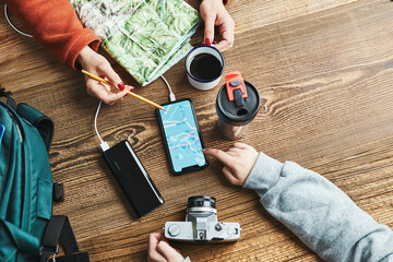 Family planning vacation trip. Girl searching travel destination and routes using navigation map on mobile phone. Charging smartphone with power bank. Using technology while travelling