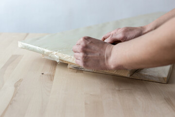 Unpacking a furniture board with a knife. Unpacking a wooden board.