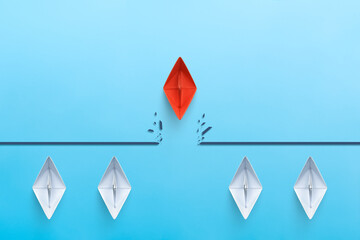 Red paper ship breaking through obstacle, Concept of overcoming barriers, goal, target
