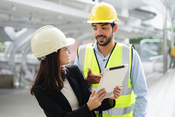 A man engineer discussing to coworker about project engineering on construction site