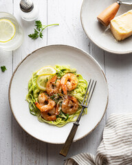 Zucchini pasta with shrimps on white wooden background, top view 