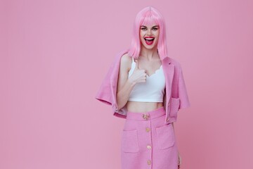 Positive young woman gestures with his hands with a pink jacket pink background unaltered