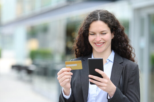Happy businesswoman buying online with credit card and phone