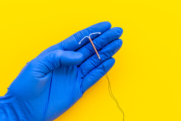 Doctor gynecologist holding intrauterine contraceptive device. T-shaped copper contraceptive