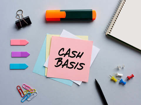 The word cash basis written on a notepaper on business office desktop.