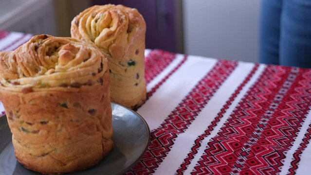 young woman puts fresh baked easter cake cruffin on kitchen table