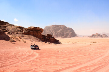 Jeep safari in Wadi Rum desert, Jordan. Tourists in car ride on off-road on sand among the beautiful rocks