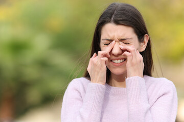 Teen scratching itchy eyes complaining outdoors