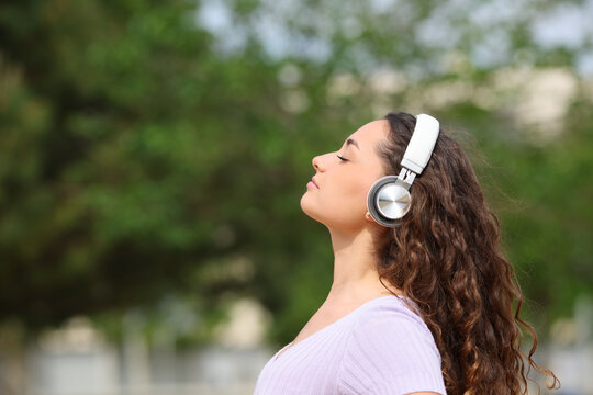 Woman listening audiobook meditating in a park