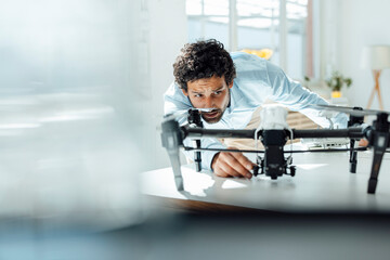 Businessman analyzing drone at desk in office