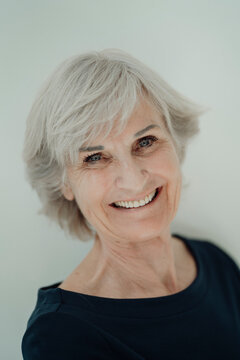 Happy senior woman with gray hair against white background
