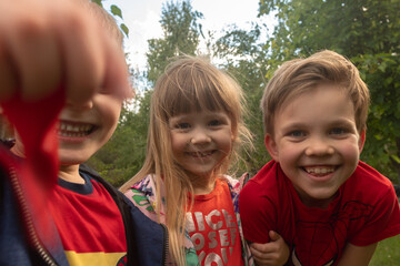Close up of siblings  in a park smiling to camera