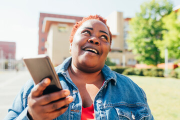 Smiling woman holding mobile phone in the city