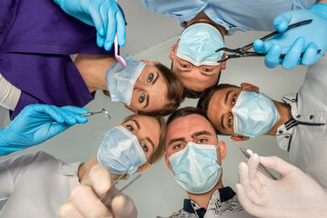 A large group of motivated doctors and nurses standing in a circle and joking with each other.