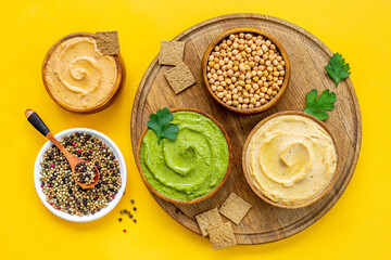 Flatlay of vegetarian hummus in bowls with chickpeas