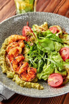 Grilled shrimps with pesto, mix of salads and tomatoes.