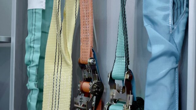Different types and sizes are presented at the exhibition lashing strap for fixing loads. Close up. Shot in motion