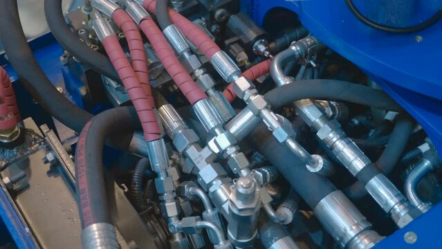 A unit of industrial equipment where the accumulation of hydraulic hoses and valves ensures the operation of the mechanism. Close up. Shot in motion