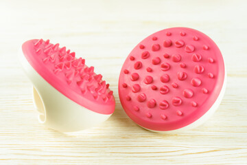 Hand massager with silicone spikes for anti-cellulite massage procedure on white wooden background. Massage brush tool for problem body zone, self-care, health care, body therapy.