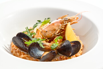 Italian dish - seafood risotto on white plate. Risotto frutti di mare with shrimp, mussels and squid. Seafood in marinara sauce with arborio rice. Paella with prawn and mussels. Seafood menu.
