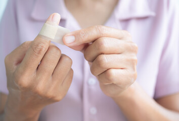 Woman use close Medical plaster on knife wound finger.first aid for lifestyle concept.
