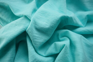 Wrinkled pale blue jersey, soft fabric wavy background