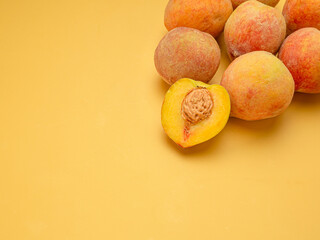 Pile of fresh peaches fruit over a yellow background