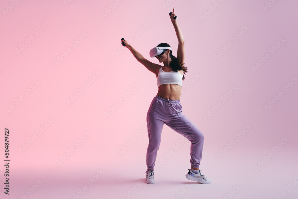 Wall mural cheerful young woman dancing in virtual reality