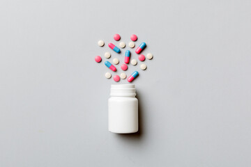 Multicolored pills and capsules in plastic bottle on Colored background, copy space. Many different...