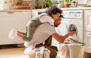Father and son doing laundry together - obrazy, fototapety, plakaty