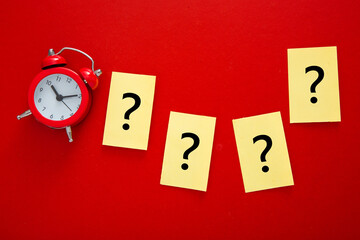a question mark and a red alarm clock . FAQ frequency asked questions.