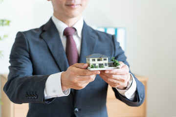 住宅の模型を持つビジネスマン