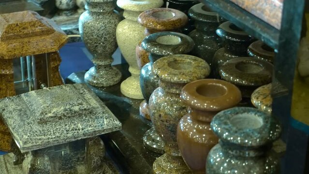 Grave vases for flowers from stone different colors at the exhibition of funeral services. Close up. Shot in motion