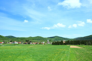 Obraz premium Green meadow and panoramic view on village Mrkopalj in Gorski kotar area, Croatia