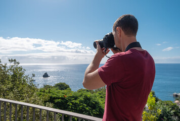 Obraz premium Phortographer taking picture at Madeira coastline, travel photography