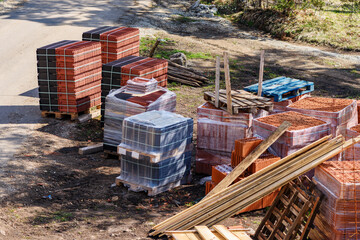 Construction material on building site - planks, blocks and roof tiles