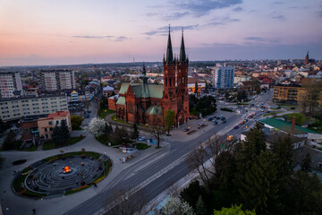 Fototapeta na wymiar Holy Family Cathedral Church in Tarnow, Poland. Skyline of City Illuminated at Dusk. Cityscape and Architecture from Above.