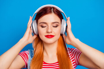 Photo of sweet adorable young lady dressed denim clothes enjoying songs earphones isolated blue color background