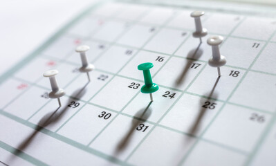Calendar appointment thumbtacks in various dates on calendar diary