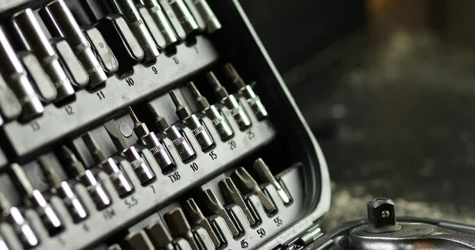 Man hand take working tools from set box with different types of metal steel heads and bits at the workshop, Interchangeable screwdriver set.